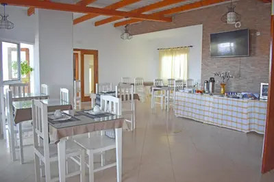 a restaurant with white chairs and tables and a counter at Damfjord Boutique Hotel in Santa Maria