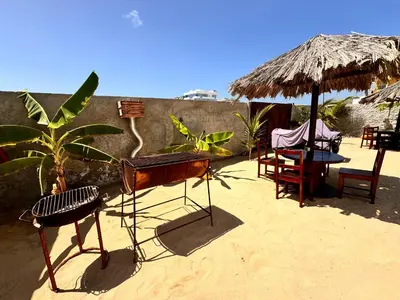a patio with a table and chairs and an umbrella at Vilas na areia aparthotel in Sal Rei