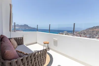 a balcony with a couch and a view of the ocean at Penthouse with jacuzzi and sea view, Morabeza Deluxe in Mindelo