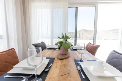 a dining room with a table with wine glasses at Penthouse with jacuzzi and sea view, Morabeza Deluxe in Mindelo