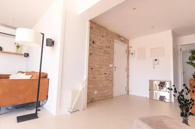 a living room with white walls and a brick wall at Penthouse with jacuzzi and sea view, Morabeza Deluxe in Mindelo