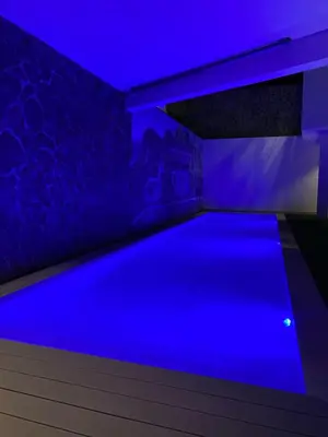 a pool in a room with blue lighting at Hotel Château Georgette in Pombas
