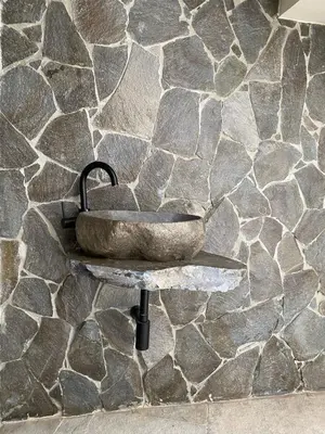 a stone sink on a stone wall at Hotel Château Georgette in Pombas