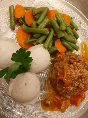 a plate of food with meatballs and vegetables on it at Hotel Château Georgette in Pombas