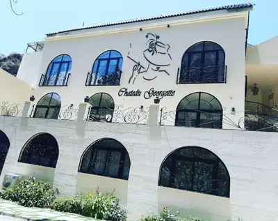 a building with a sign on the side of it at Hotel Château Georgette in Pombas