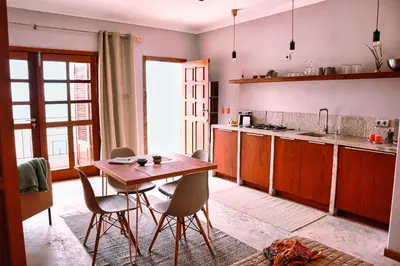 a kitchen with a wooden table and chairs in it at Leben am Atlantik hautnah spüren in Sal Rei