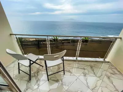 a balcony with two chairs and a view of the ocean at Cruzeiro Guest House in São Filipe