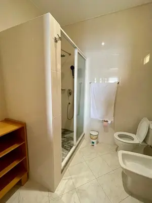 a bathroom with a shower and a toilet and a sink at Cruzeiro Guest House in São Filipe