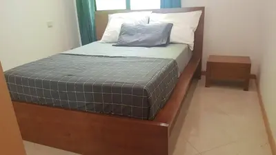 a bed with a wooden frame and a pillow on it at Casa JPi in São Pedro