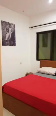 a bedroom with a red bed and a picture on the wall at Casa JPi in São Pedro