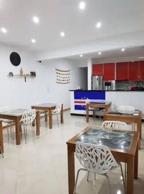 a dining room with tables and chairs and a kitchen at Casa JPi in São Pedro