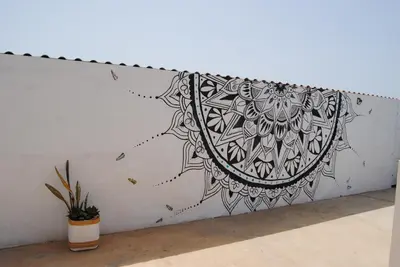 a wall with a black and white mandala on it at AMA Apartament Ponta Preta in Calheta Do Maio