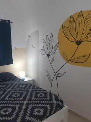 a bedroom with a flower mural on the wall at AMA Apartament Ponta Preta in Calheta Do Maio