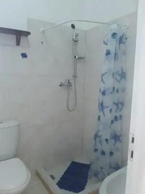a bathroom with a shower with a blue shower curtain at AMA Apartament Ponta Preta in Calheta Do Maio