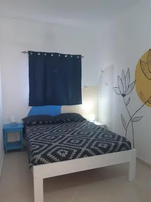 a bedroom with a bed with a blue curtain at AMA Apartament Ponta Preta in Calheta Do Maio