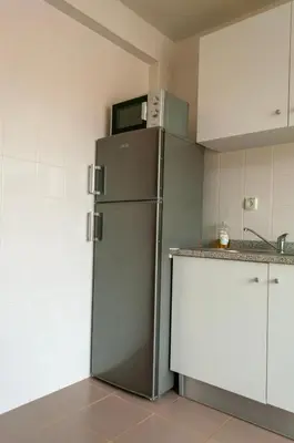 a refrigerator with a microwave on top of it in a kitchen at Brand New Chic Appt in Mindelo at Great Rates in Mindelo