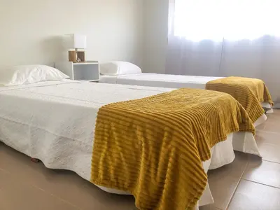 two beds with yellow blankets on them in a room at Brand New Chic Appt in Mindelo at Great Rates in Mindelo
