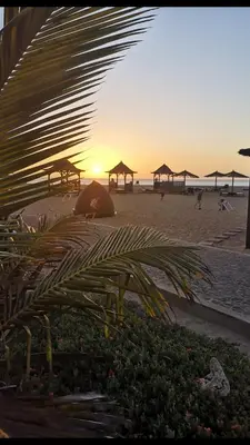 a sunset on a beach with umbrellas and the ocean at Ocean Roof in Santa Maria