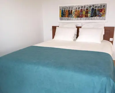 a bed with a blue blanket on top of it at Ocean Roof in Santa Maria