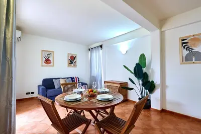 a dining room table with chairs and a blue couch at Patio Antigo Residence in Santa Maria
