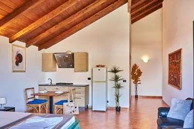 a kitchen and living room with a table and a refrigerator at Patio Antigo Residence in Santa Maria