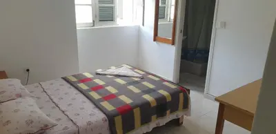 a room with a bed with a blanket on it at Residencial Bibi in Ribeira Grande