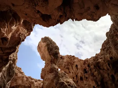 a view of the sky through a rock formation at Apartamento Os Bidons in Praia