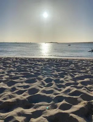 a sandy beach with the sun rising over the ocean at Zodiaco Apartments in Sal Rei