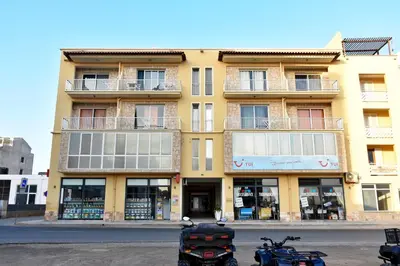 a yellow building with motorcycles parked in front of it at Zodiaco Apartments in Sal Rei