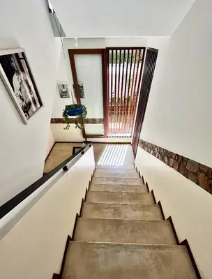 a staircase in a house with a window at Casa de Poço Guest House and Gallery in Mindelo