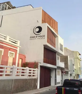 a building with a sign on the side of it at Casa de Poço Guest House and Gallery in Mindelo