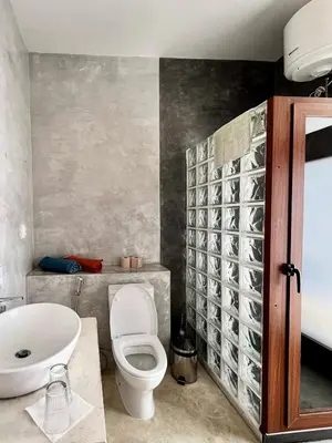 a bathroom with a toilet and a sink at Casa de Poço Guest House and Gallery in Mindelo