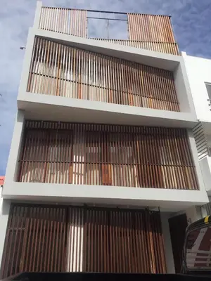 a tall building with brown doors on it at Casa de Poço Guest House and Gallery in Mindelo