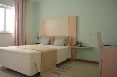 a bedroom with a large bed and a telephone at Sol Hotel in Praia
