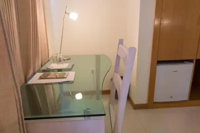 a glass table with a lamp and a book on it at Sol Hotel in Praia