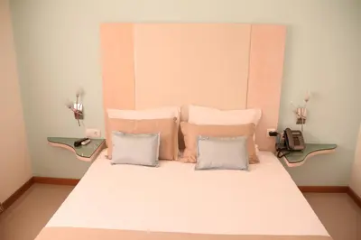 a bed with white sheets and pillows in a room at Sol Hotel in Praia