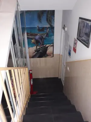 a stairway with a picture of a dinosaur on the wall at Yria Residencial in Porto Novo