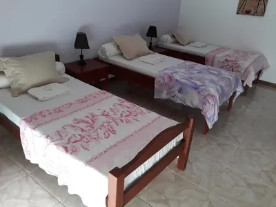 a room with two beds and two tables at Yria Residencial in Porto Novo