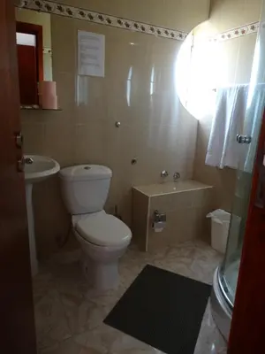 a bathroom with a toilet and a sink at Yria Residencial in Porto Novo