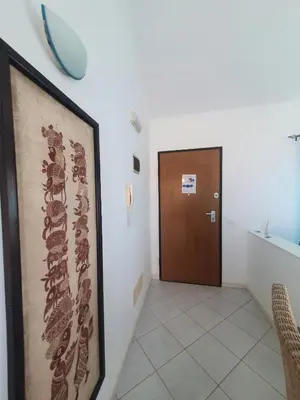 a hallway with a door and a picture on the wall at Santa Maria Borgo Verde Apartment T2 in Santa Maria