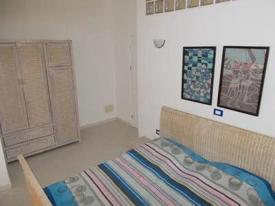 a bedroom with a bed and some pictures on the wall at Santa Maria Borgo Verde Apartment T2 in Santa Maria