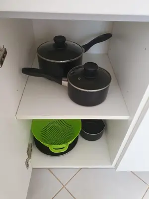 two pots and pans on a shelf in a drawer at Santa Maria Borgo Verde Apartment T2 in Santa Maria