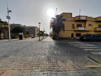 a cobblestone street with a building and a palm tree at Santa Maria Borgo Verde Apartment T2 in Santa Maria