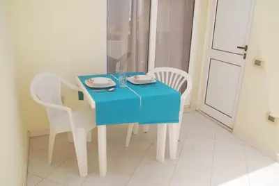a blue table with white chairs and a blue table cloth at Santa Maria Borgo Verde Apartment T2 in Santa Maria