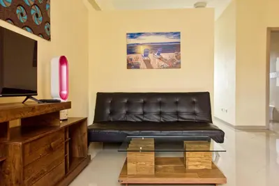 a living room with a leather couch and a table at Praia Capital Residence Aparthotel in Praia