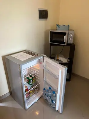 a refrigerator with its door open next to a microwave at Praia Capital Residence Aparthotel in Praia