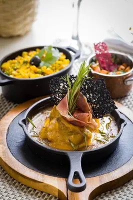 a plate of food on a table with other foods at Oasis Tarrafal Alfandega Suites in Tarrafal
