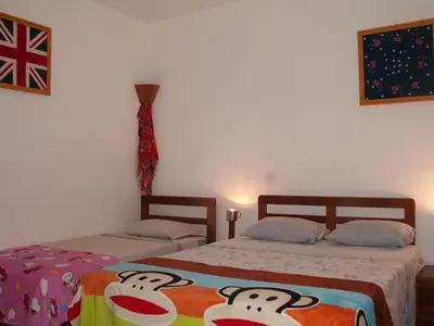 a bedroom with two beds and a flag on the wall at Edificio Magico in Tarrafal