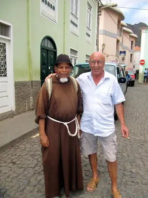 two men standing on a street in a costume at Edificio Magico in Tarrafal