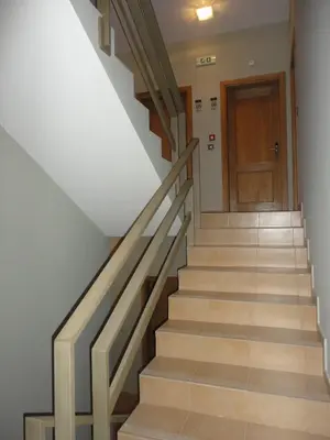 a staircase with wooden railings and a wooden door at Hotel Praia Confort in Praia
